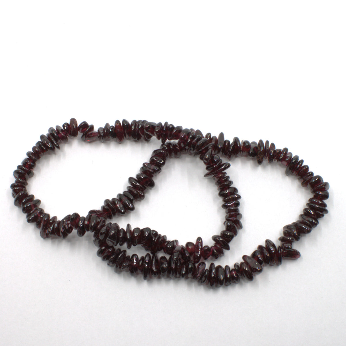Two dark red garnet beaded bracelets photographed on a table