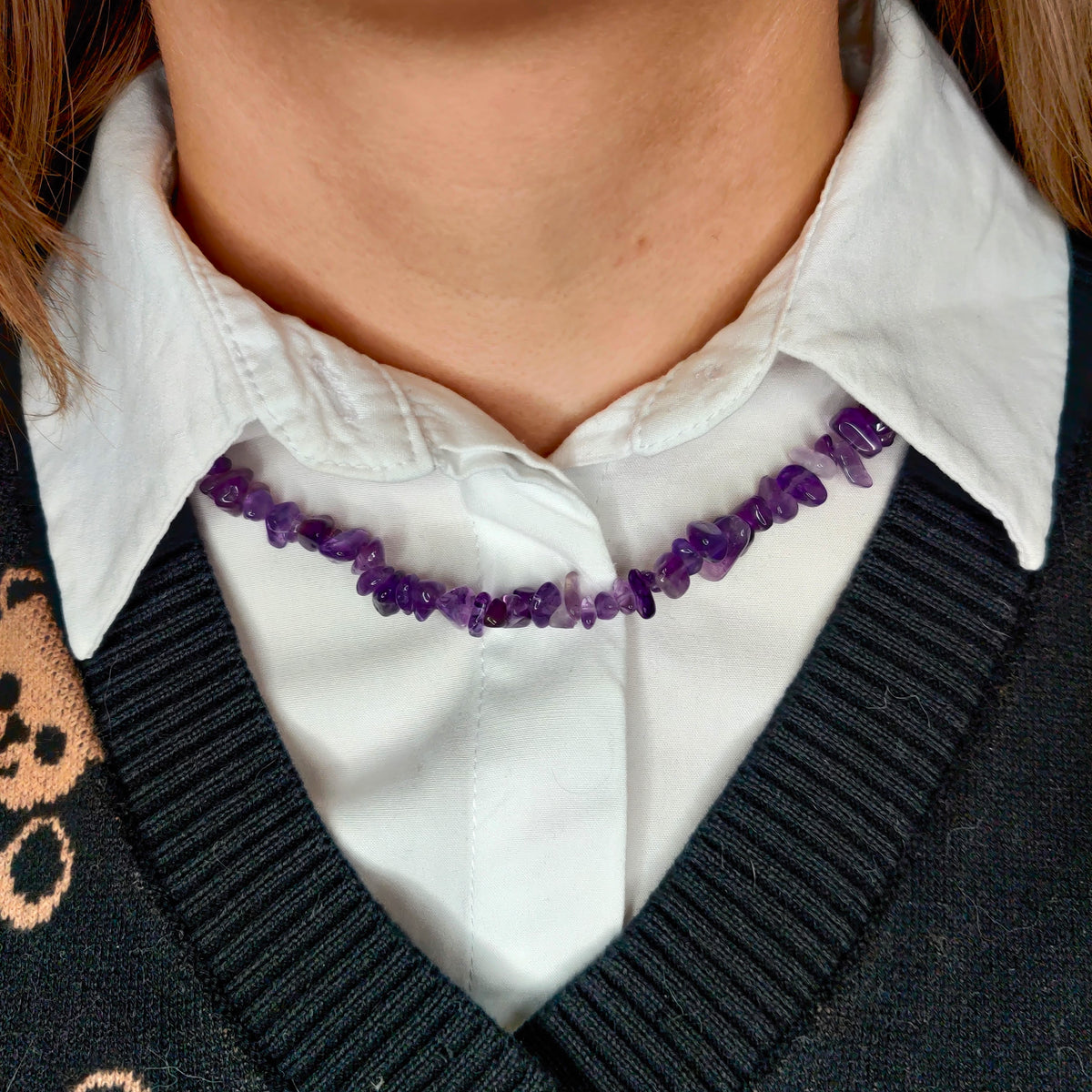 Purple amethyst nugget necklace around the neck over a collared shirt
