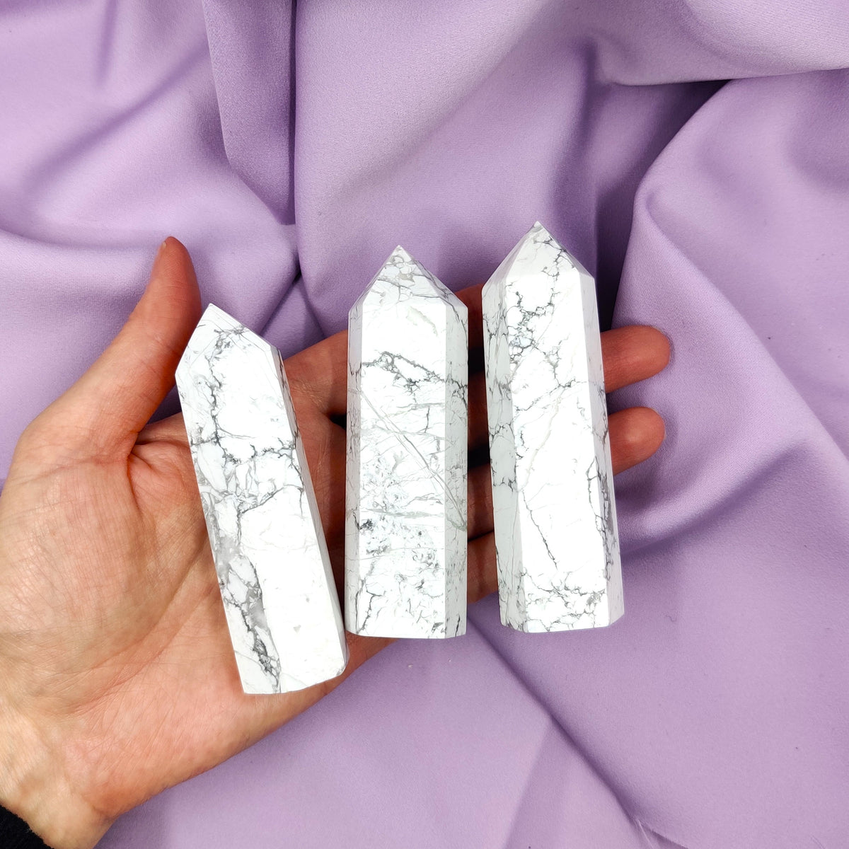 White owl towers with black stripes in hand on a purple background