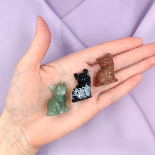 Kissakaiverrukset kädessä materiaaleina kultavirta, lumihiutaleobsidiaani, sekä vihreä aventuriini violetilla taustalla