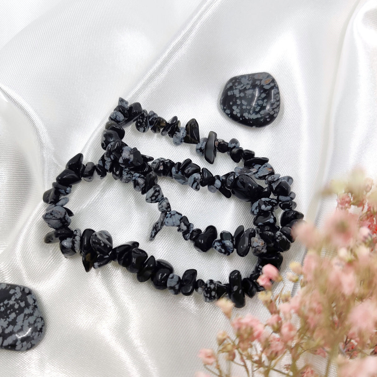 Black-and-white snowflake obsidian chip bracelets photographed with two tumbled snowflake obsidians against a white background