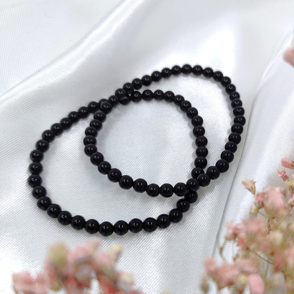 Deep black obsidian bead bracelets on a white background