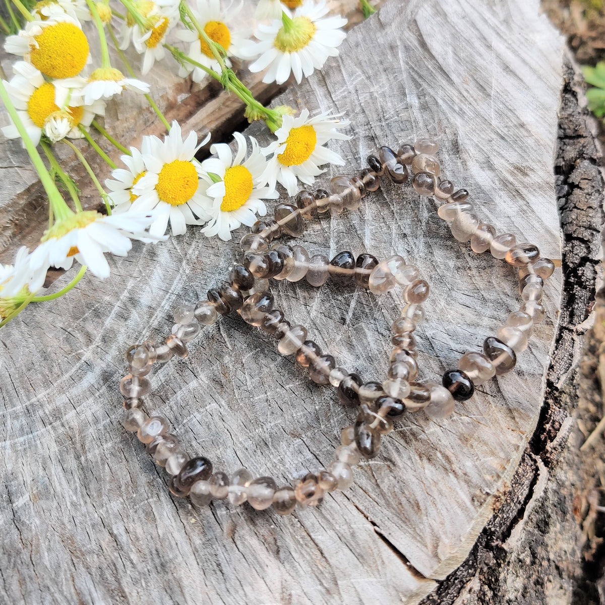 Dark smoky quartz stone jewelry photographed on gray wood