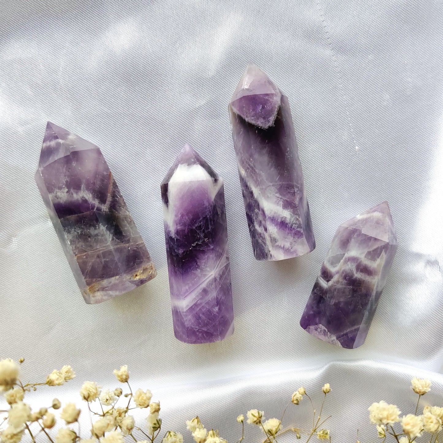 Violetit chevron ametisti kivitornit valkoisella silkkikankaalla