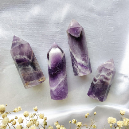 Violetit chevron ametisti kivitornit valkoisella silkkikankaalla