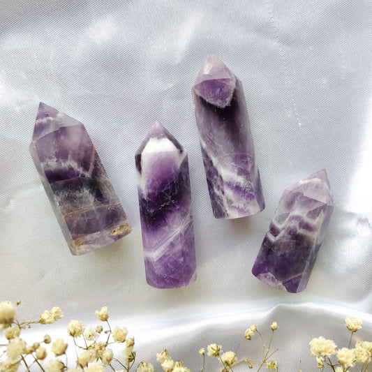 Violetit chevron ametisti kivitornit valkoisella silkkikankaalla