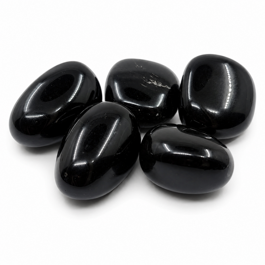 Mustat obsidiaanit läheltä kuvattuna valkoisella taustalla