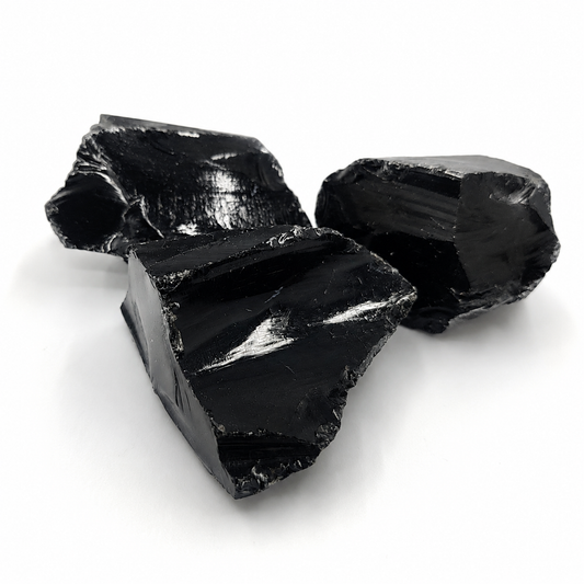 Mustat obsidiaani raakapalat läheltä kuvattuna valkoisella taustalla