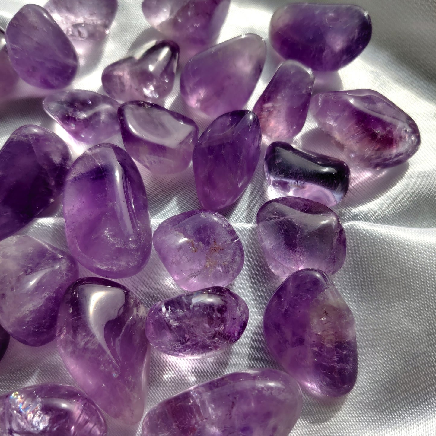violetit ametistikivet valkoisella silkkikankaalla