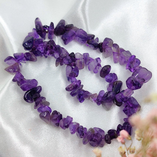 Violetti ametisti hippurannekoru valkoisella taustalla