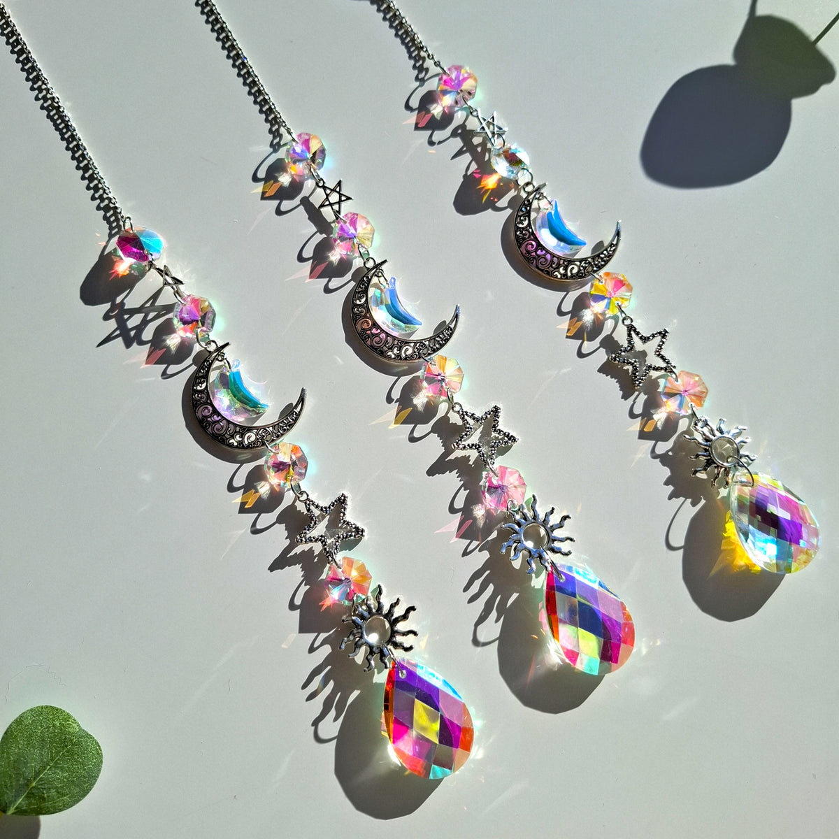 Shimmering crescent moon sun catchers photographed on a table