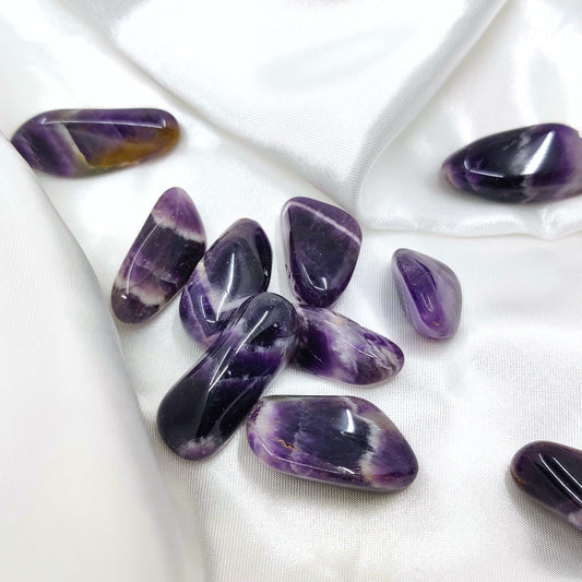 Rumpuhiotut violetin valkoiset chevron ametistit valkoisen silkkikankaan päällä