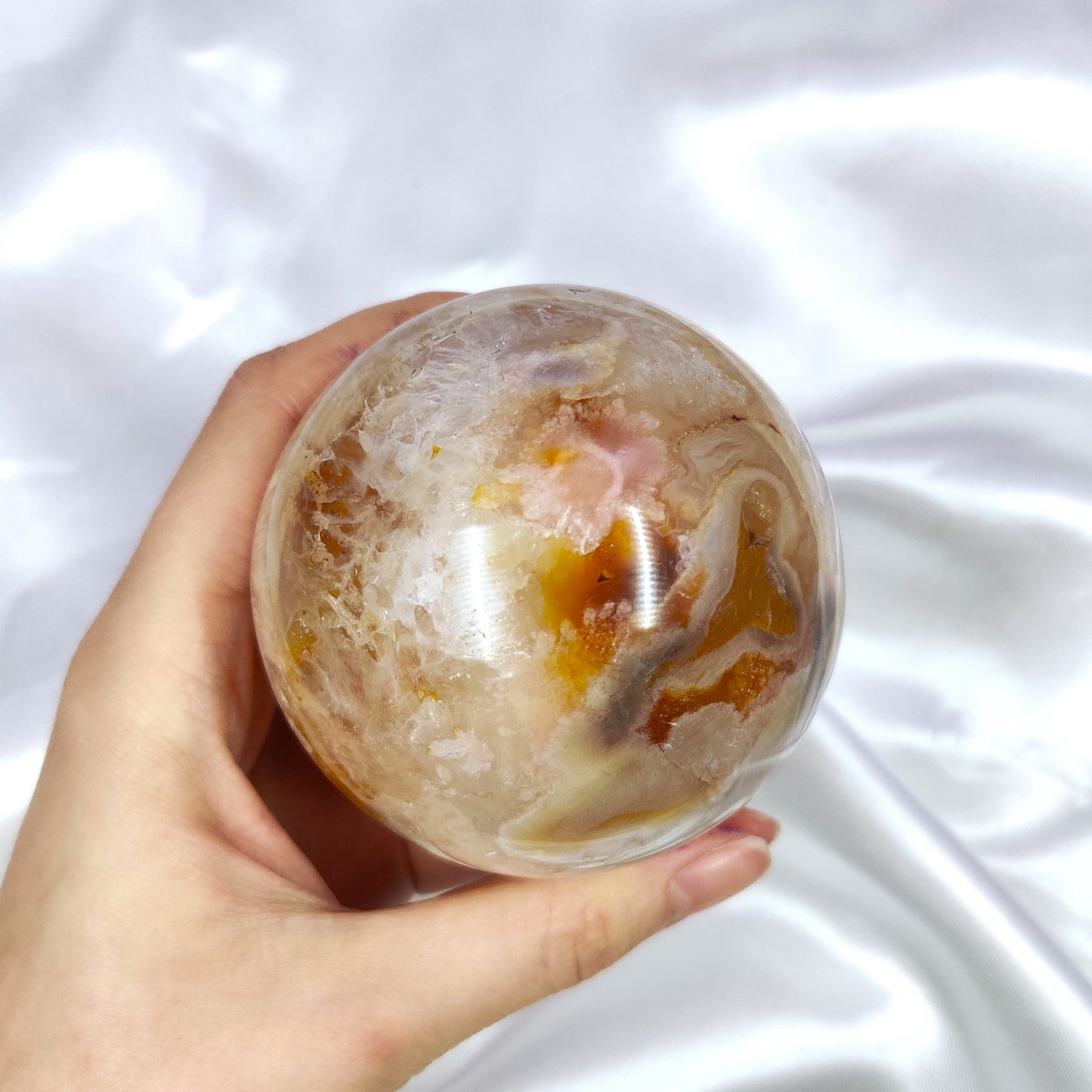 Kukka-akaatti kivikuula kauniilla kuvioilla kädessä kuvattuna