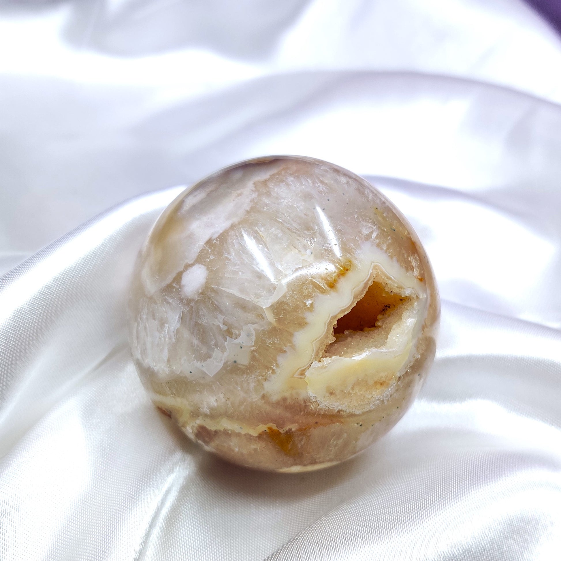 Kukka-akaatti kivipallo kauniilla druzylla ja kuvioilla pöydän päällä kuvattuna
