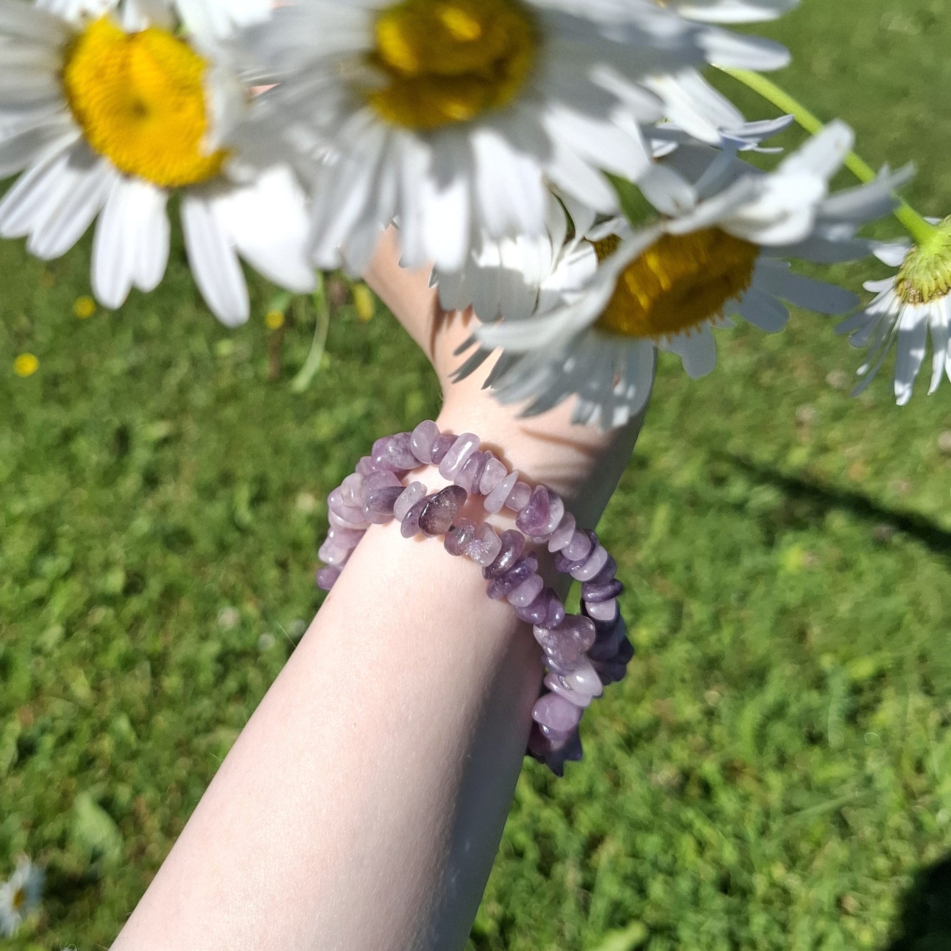 Violetit lepidoliitti hippurannekorut ranteessa kuvattuna aurinkoisena päivänä