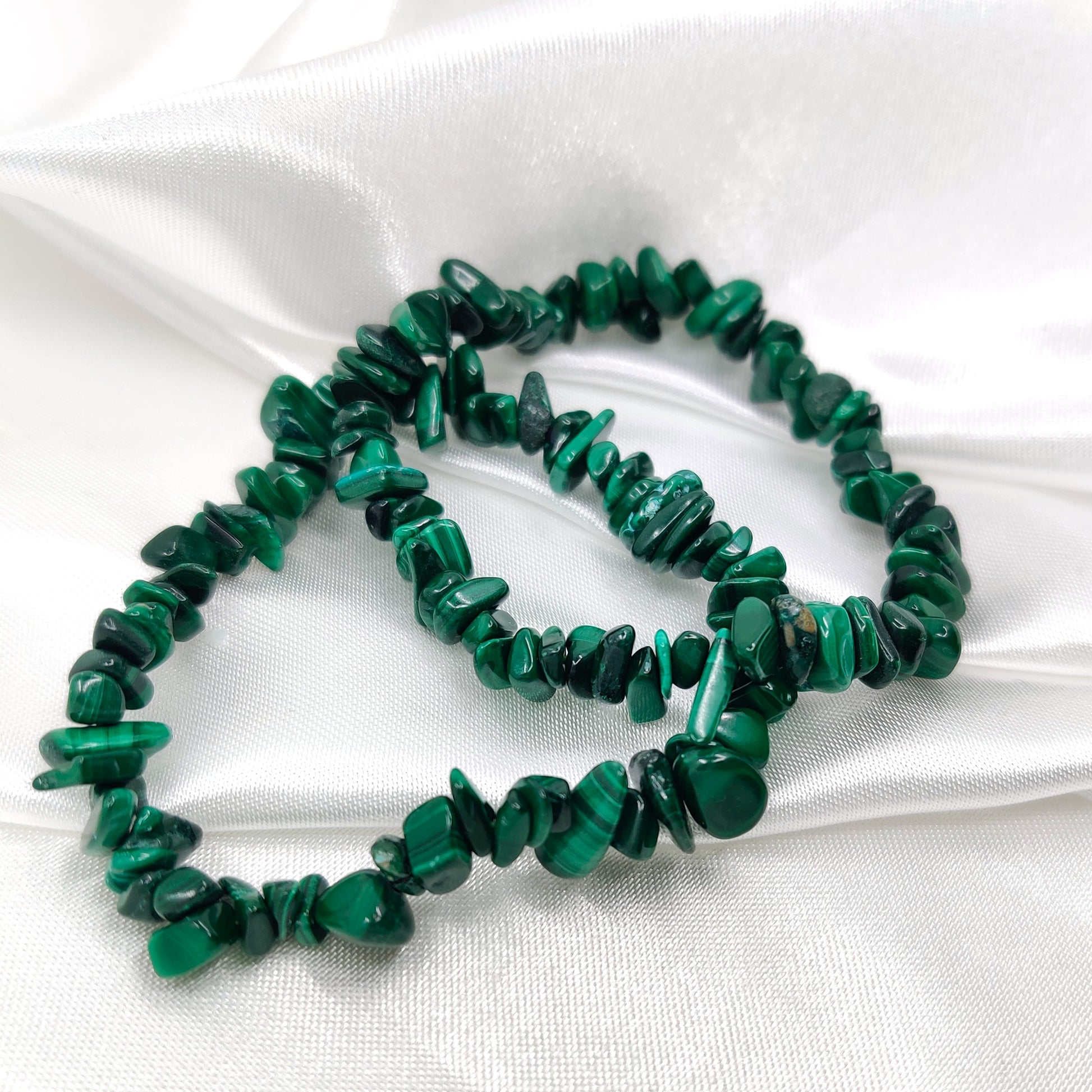 Vihreät Malakiitti hippurannekorut valkoisella silkkikankaalla