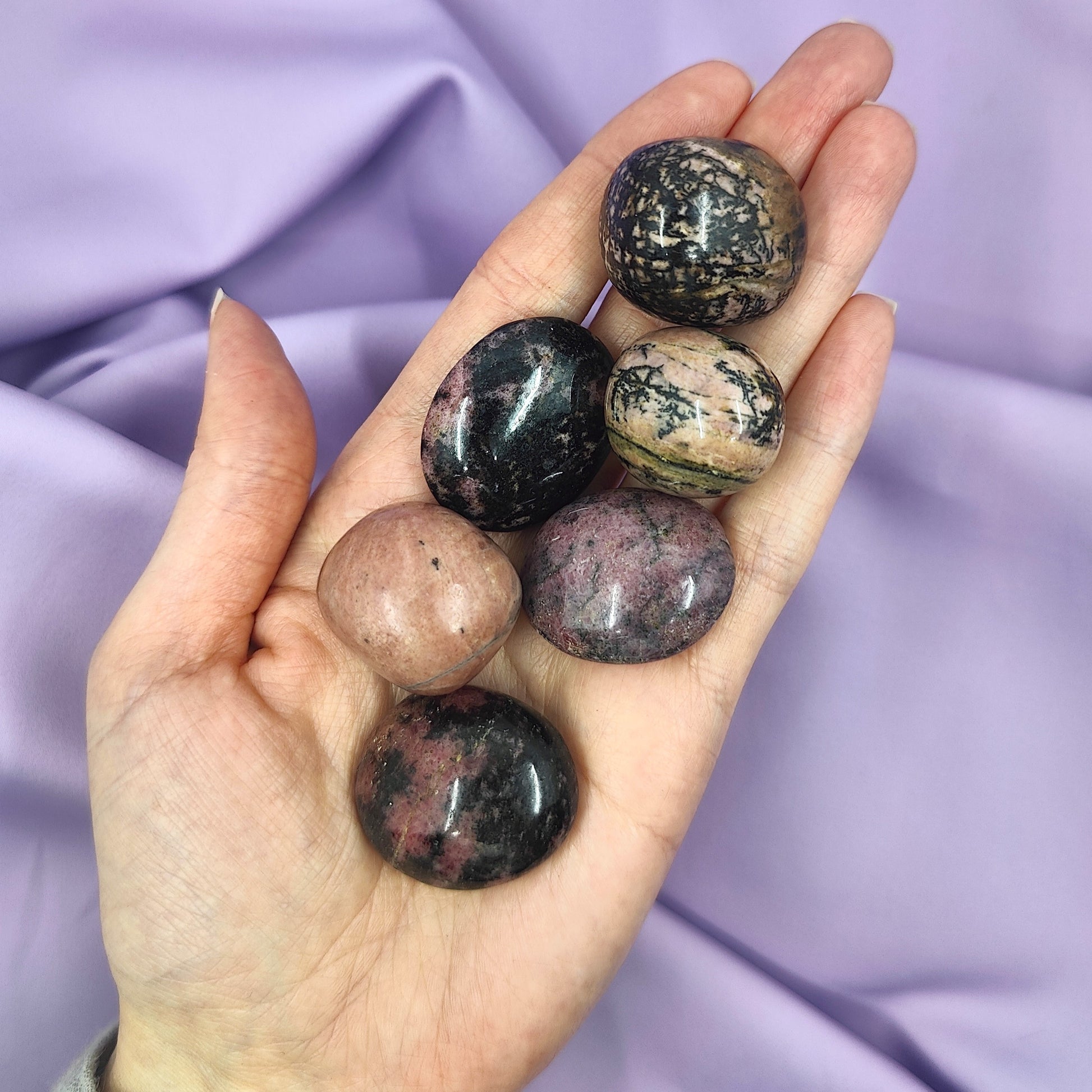 violetit ja mustat rodoniitit kädessä kuvattuna