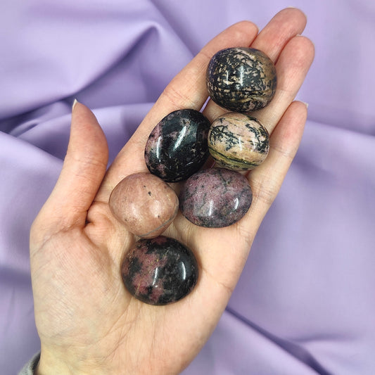 violetit ja mustat rodoniitit kädessä kuvattuna