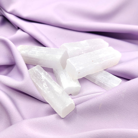 Kirkkaat seleniittisauvat violetilla silkkikankaalla