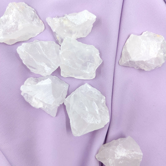 Vaaleat vuorikristalli raakapalat violetilla kankaalla